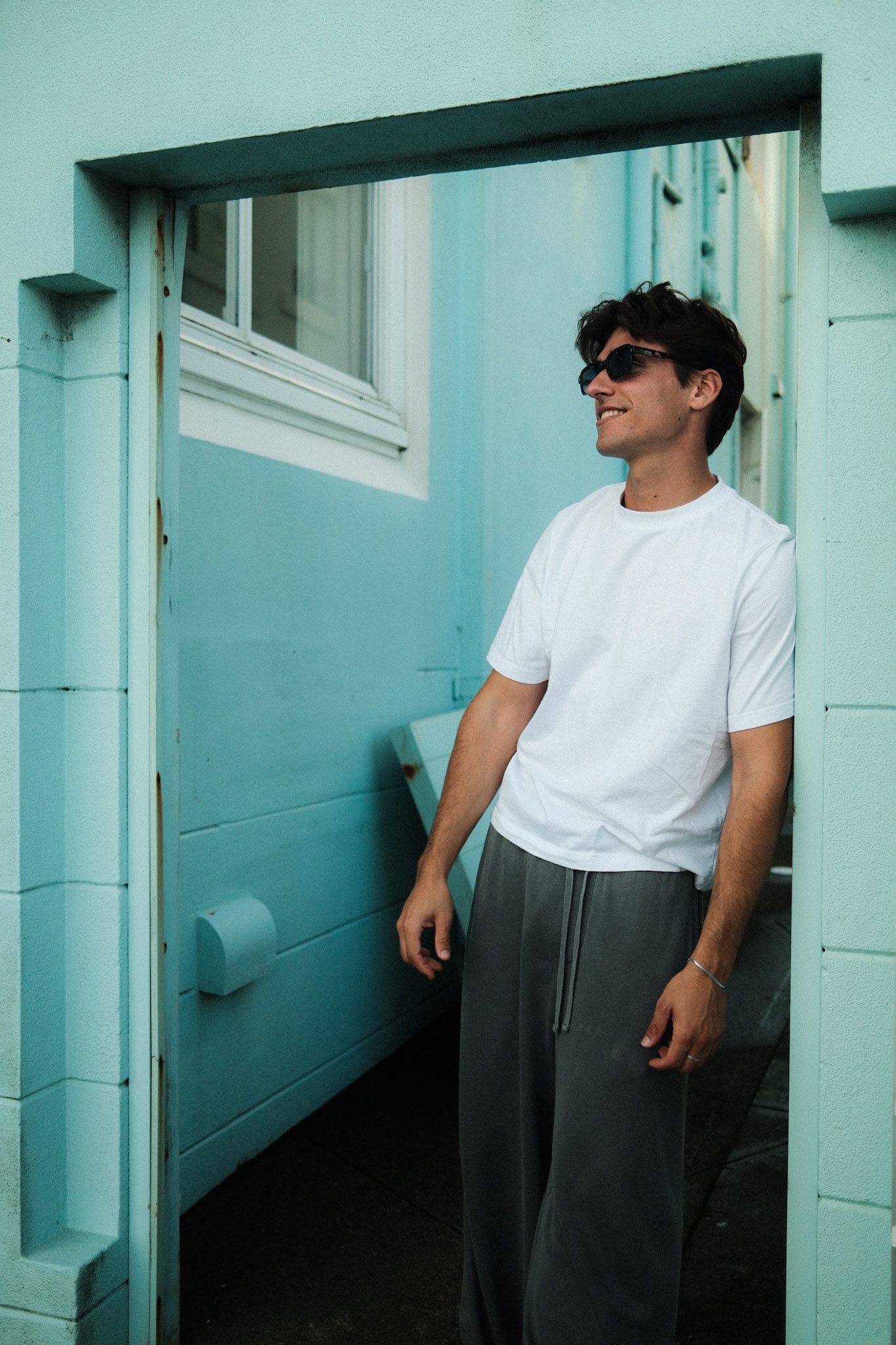 A street-style portrait against a teal doorway on Campbell Parade